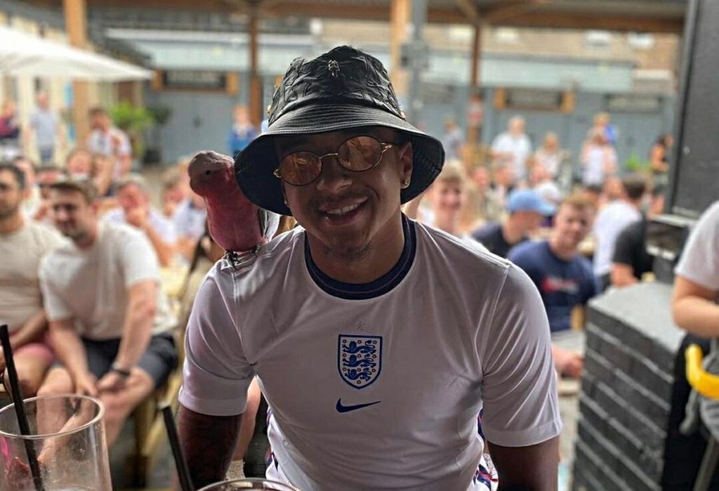 Lingard tra la gente con maglia di Rice e pappagallo sulla spalla